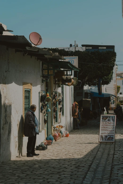 a man is standing near the shop while he waits to be sold