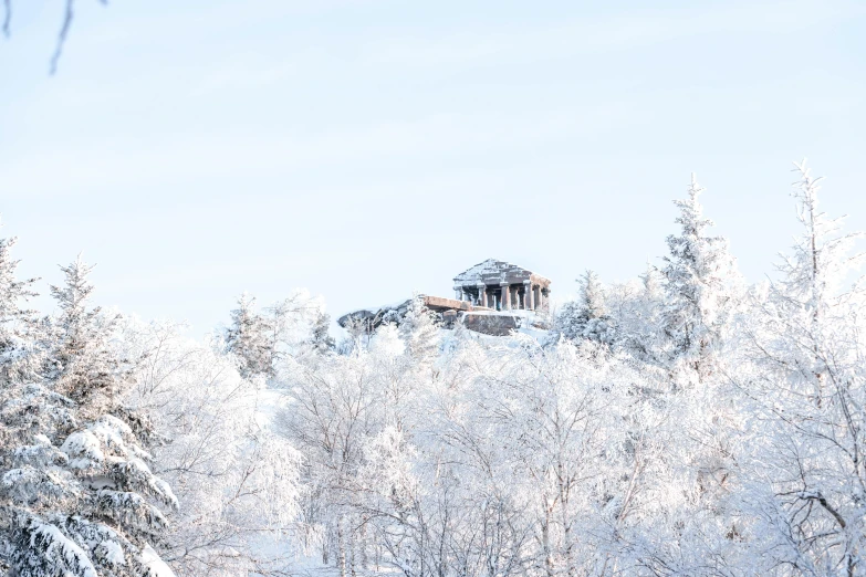 the top of a mountain with a snow covered cabin on it