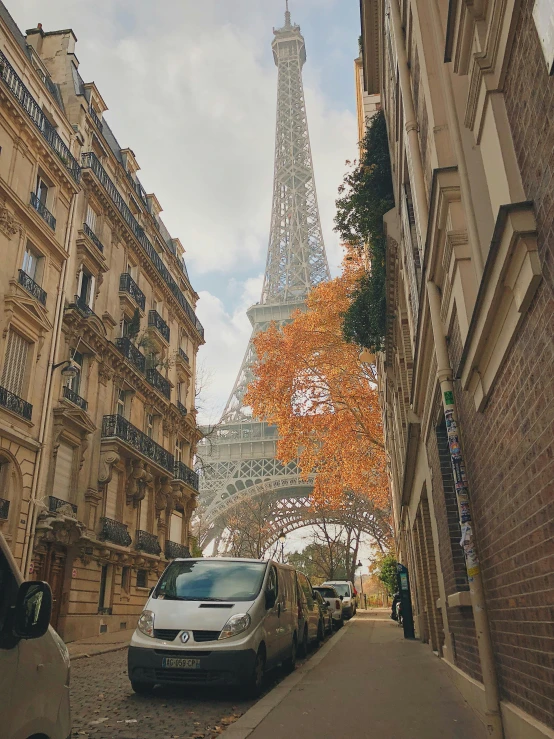 a street in front of a building with cars parked on the side of the road