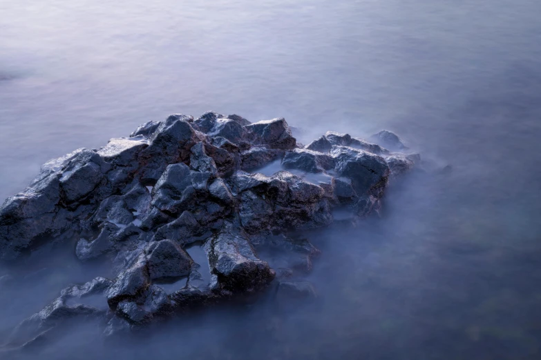 a rocky island surrounded by a thin blue sea