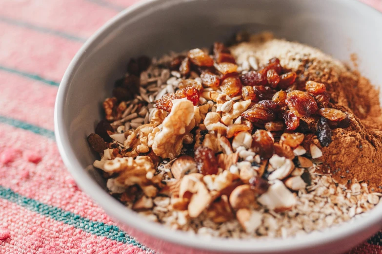 a bowl with nuts and cinnamon in it sitting on a red and white towel