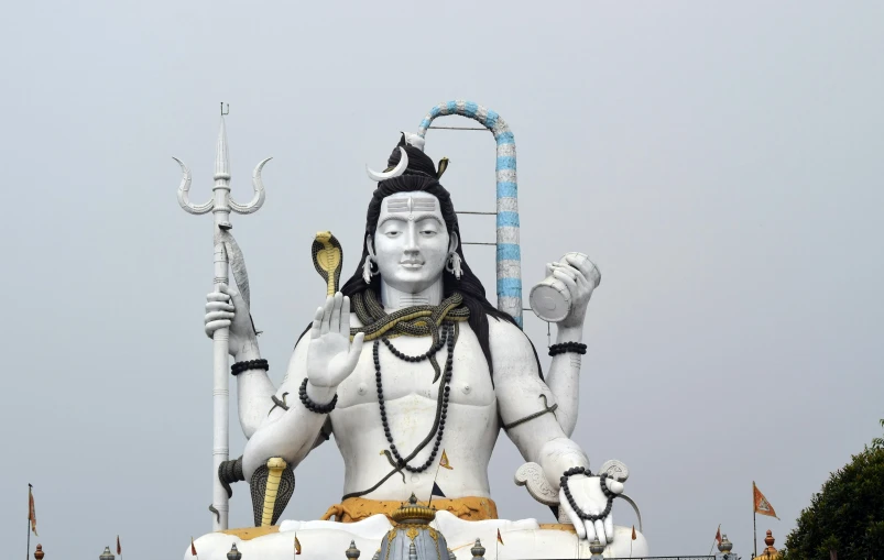 a statue of hindu god with a gold staff in his left hand