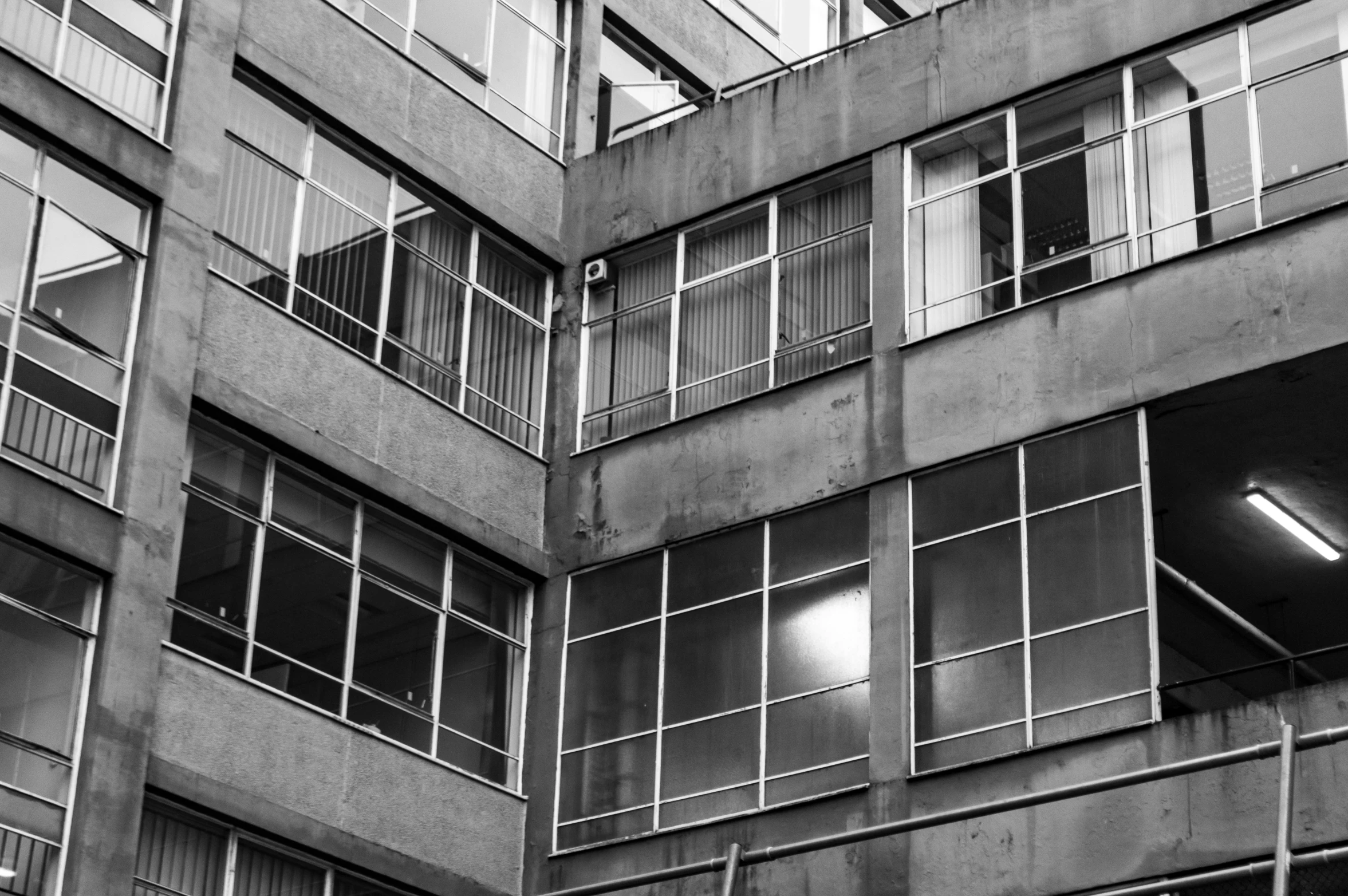 a person is sitting in the balcony of an apartment building