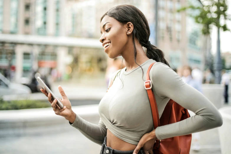 woman walking on the street looking at her cell phone