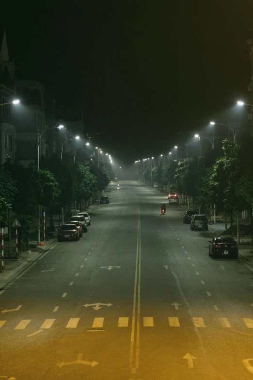 the dark night has cars driving down the street