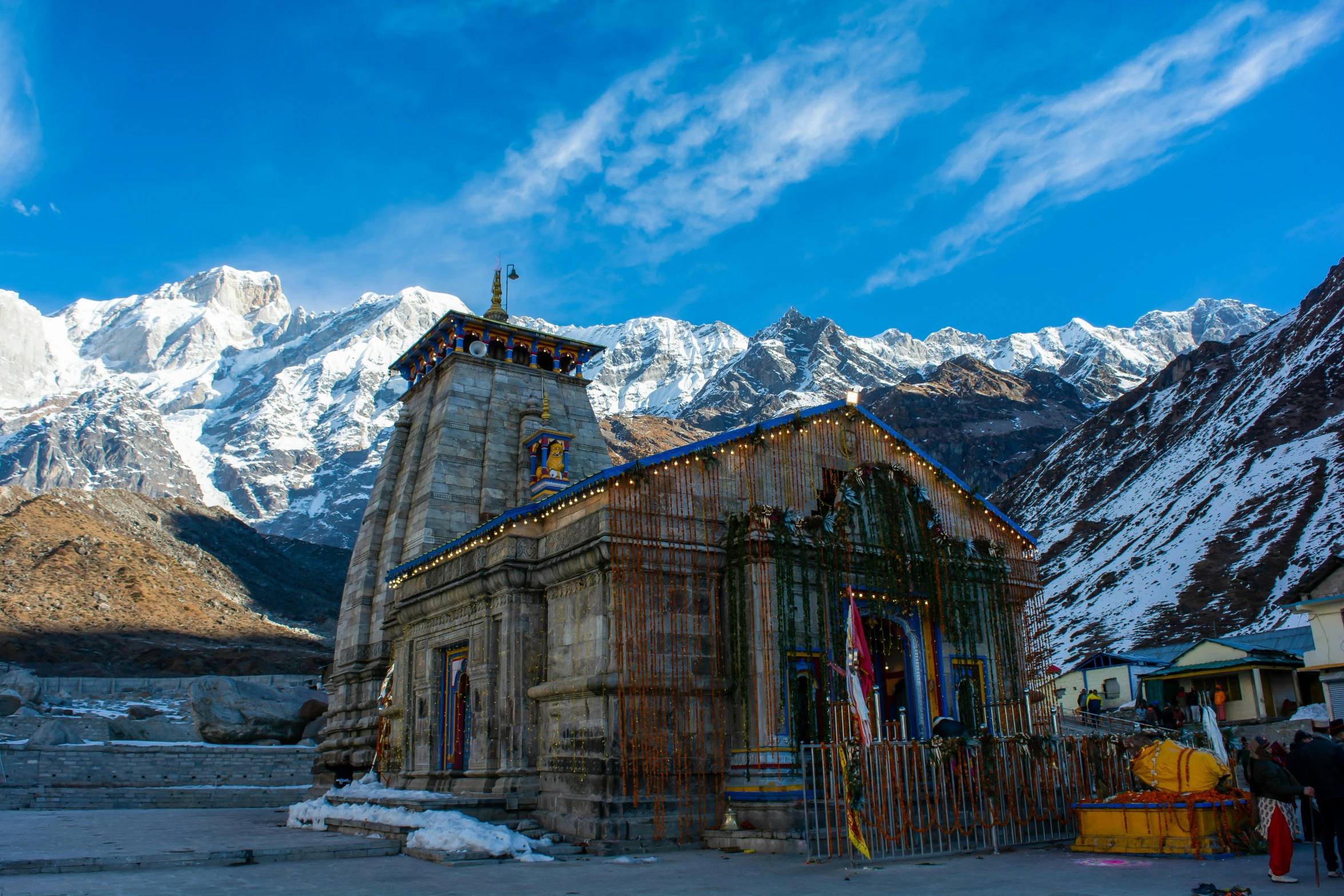 a church with a steeple surrounded by snowy mountains