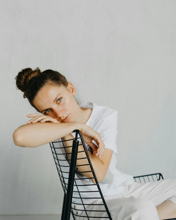 the woman is sitting on a black chair