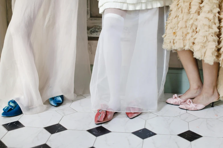 three women standing in the shower wearing matching shoes