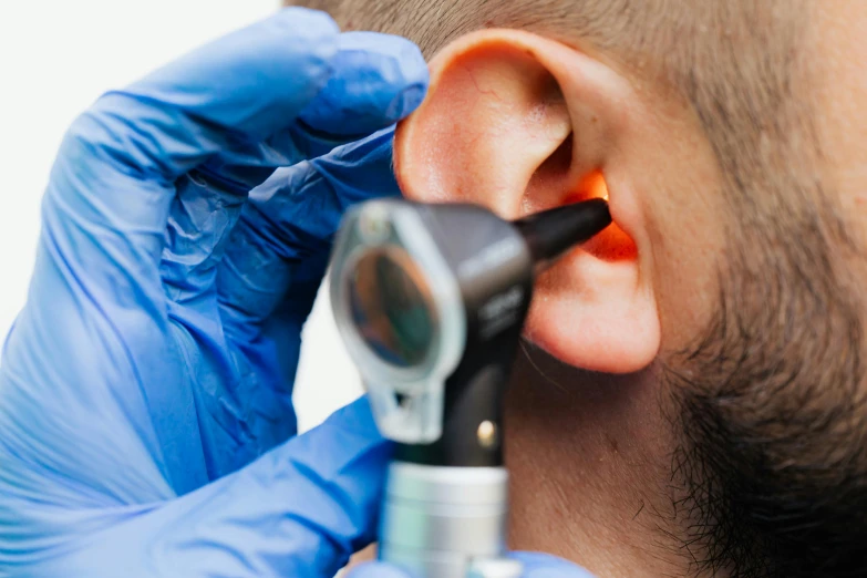 a man getting an ear examined in the back of his head