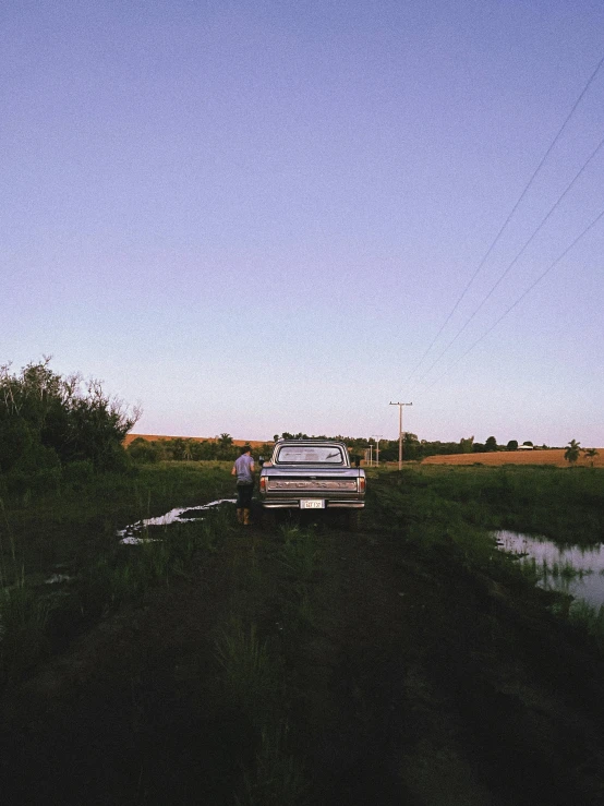 a pickup truck parked next to the side of a river