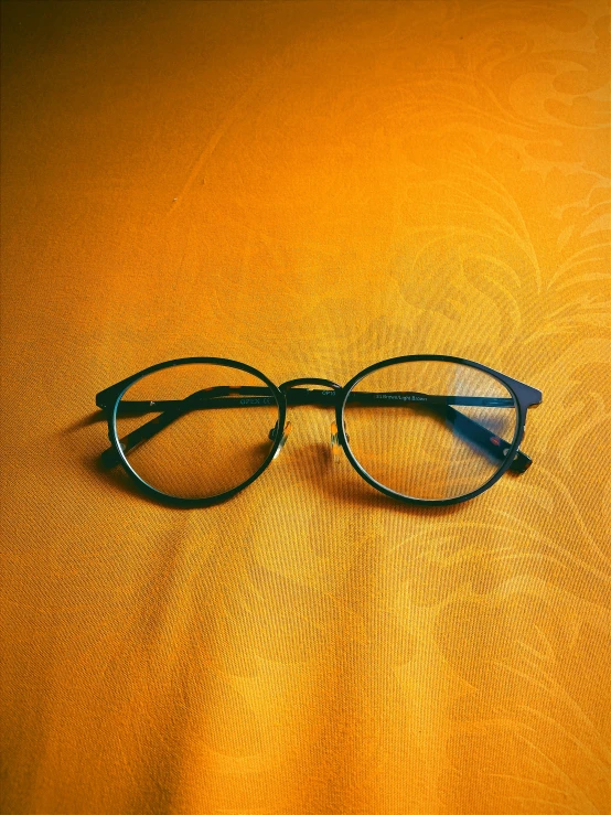 a pair of glasses lying on a yellow cloth