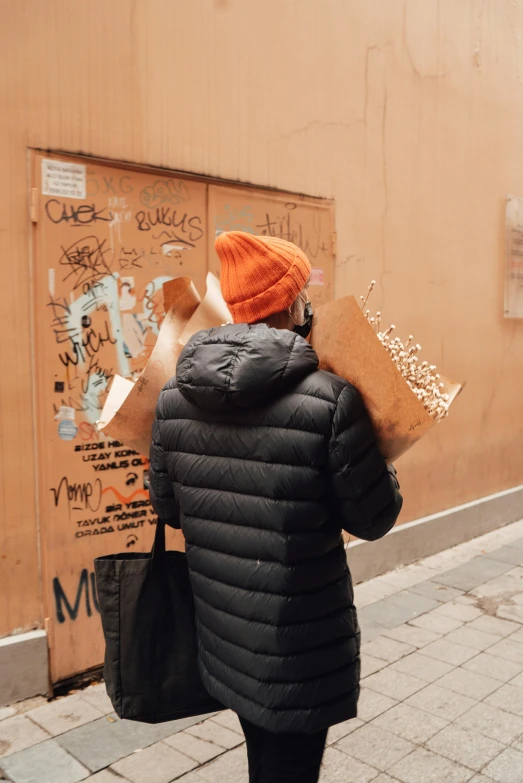 a woman walking down the sidewalk with many bags