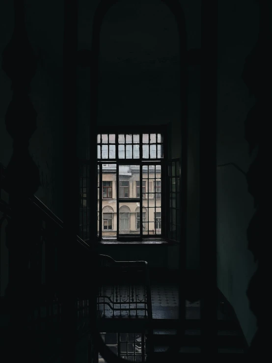 a dimly lit room with stairs and a window