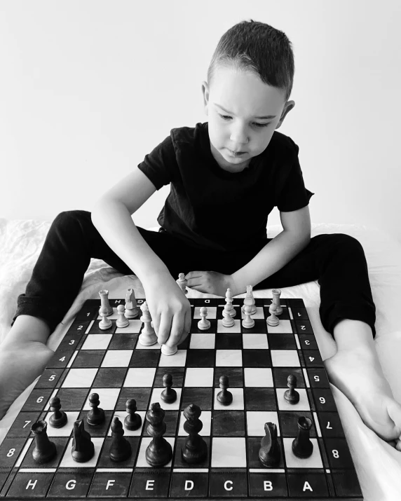 a boy sitting on the floor playing chess