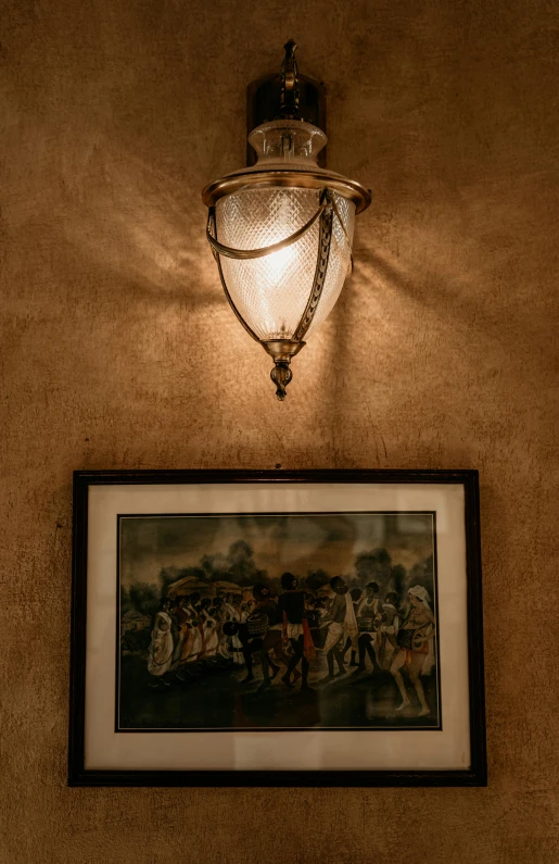a framed picture and a lamp on a wall