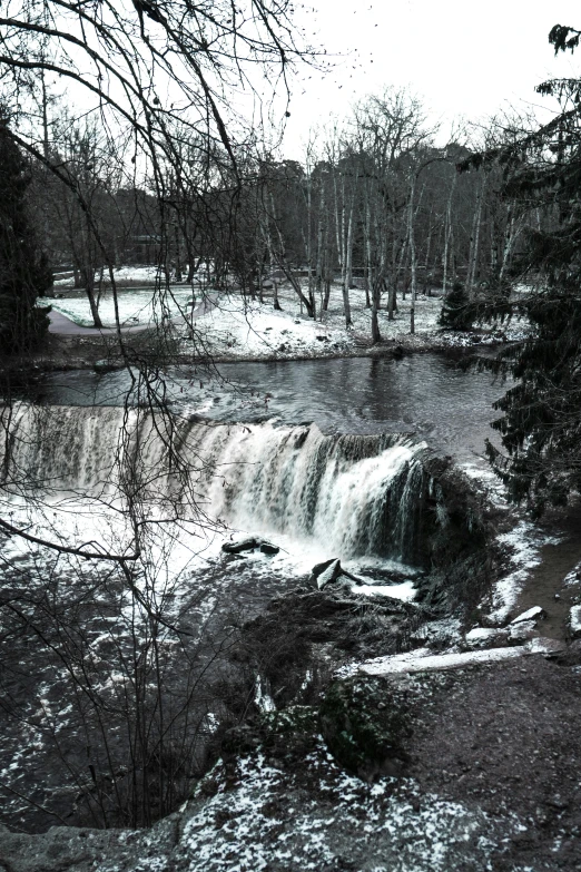 a small waterfall is in a snowy field