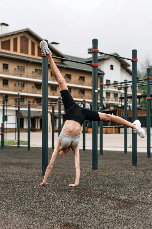 a young man performs an acrobatic trick in front of a building