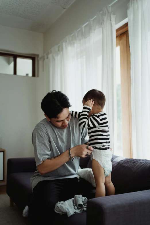 a man with a baby on his lap near a window