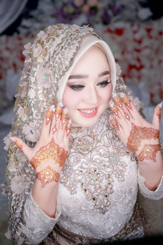 the asian woman has many gold jewelry on her hands