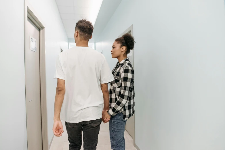 two people are walking down a hallway together