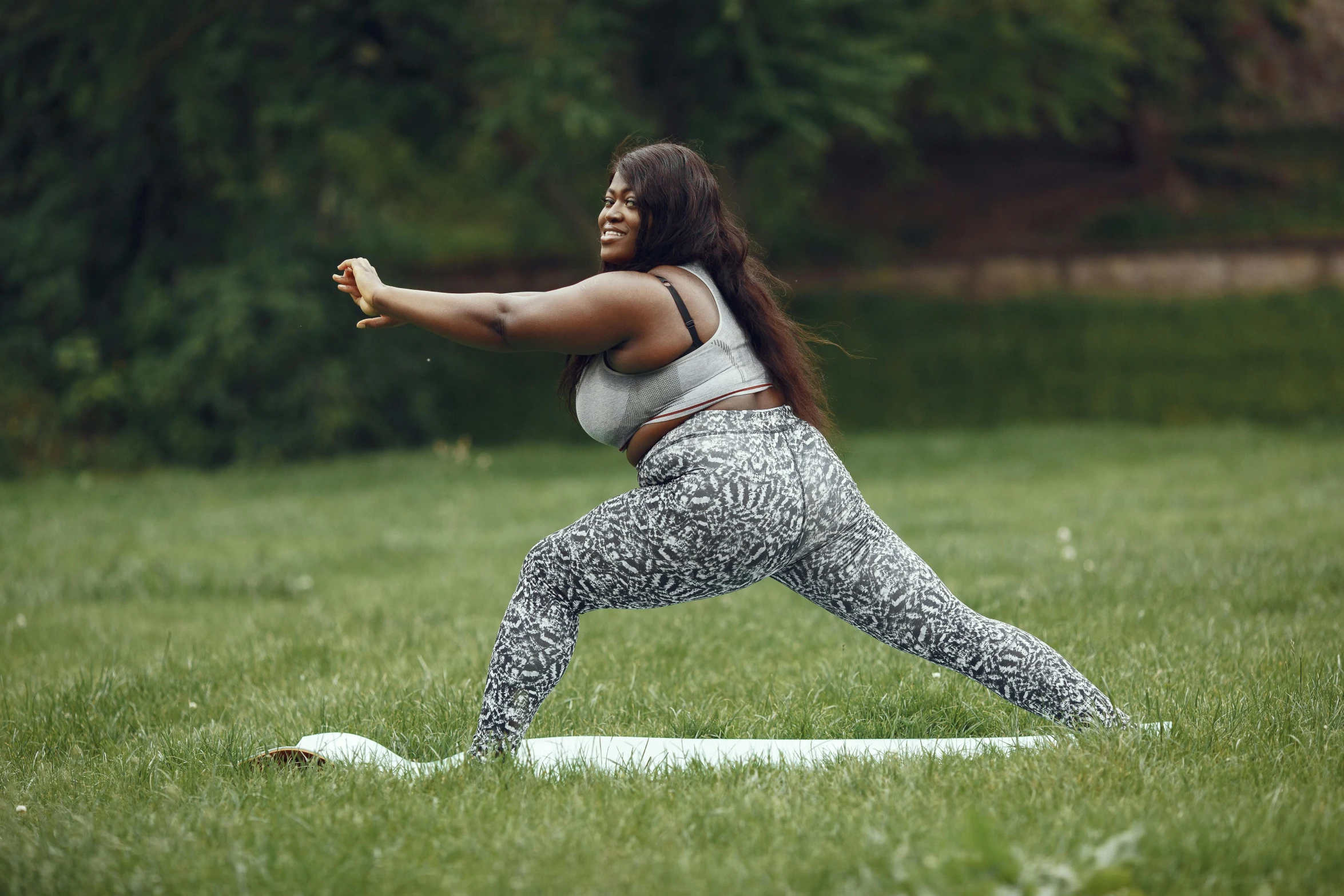 a woman standing on one leg on top of a yoga mat