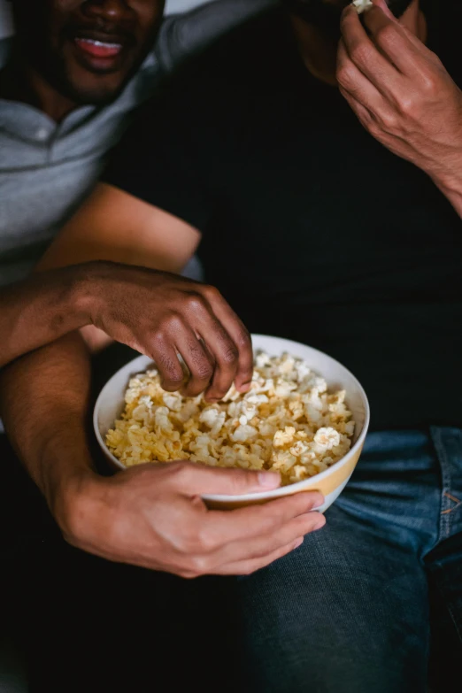 there are two men eating popcorn in front of the camera