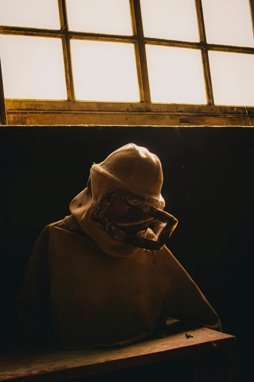 a person sitting on top of a bench wearing a mask