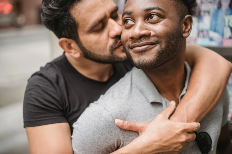 two men pose with one another as he licks the other