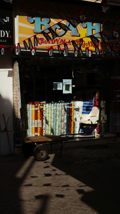 a store front with a wooden cart filled with many items