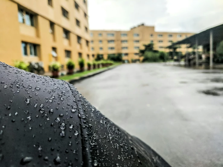 a wet umbrella sitting on the street with buildings in the background