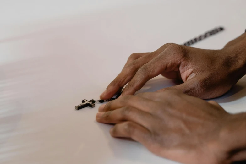 a person in black is writing on a piece of paper