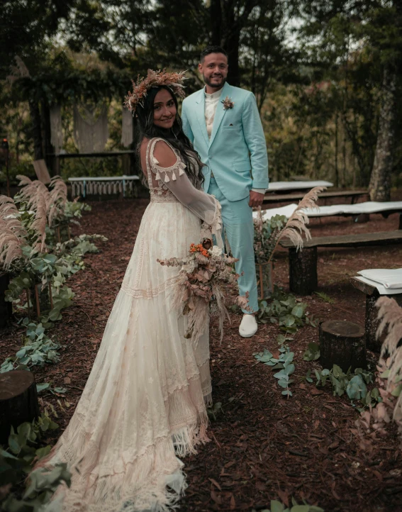 a man and woman posing for the camera wearing wedding outfits