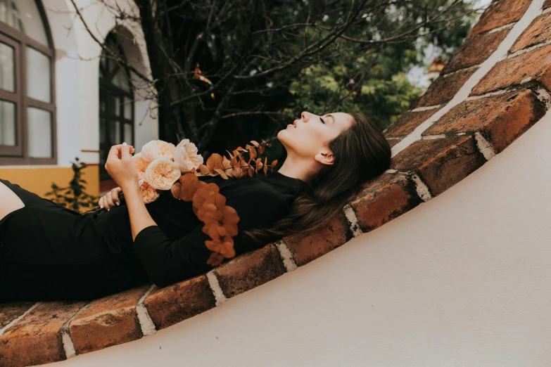 a woman is sleeping in a brick wall