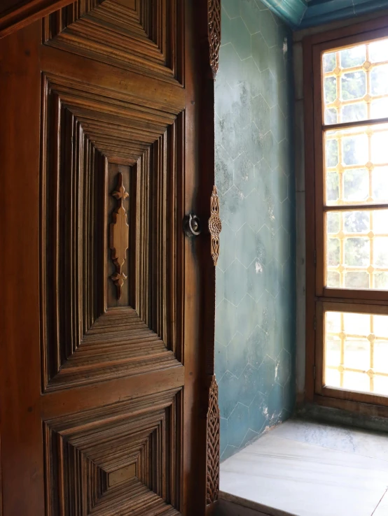 an open wooden door is in front of a window