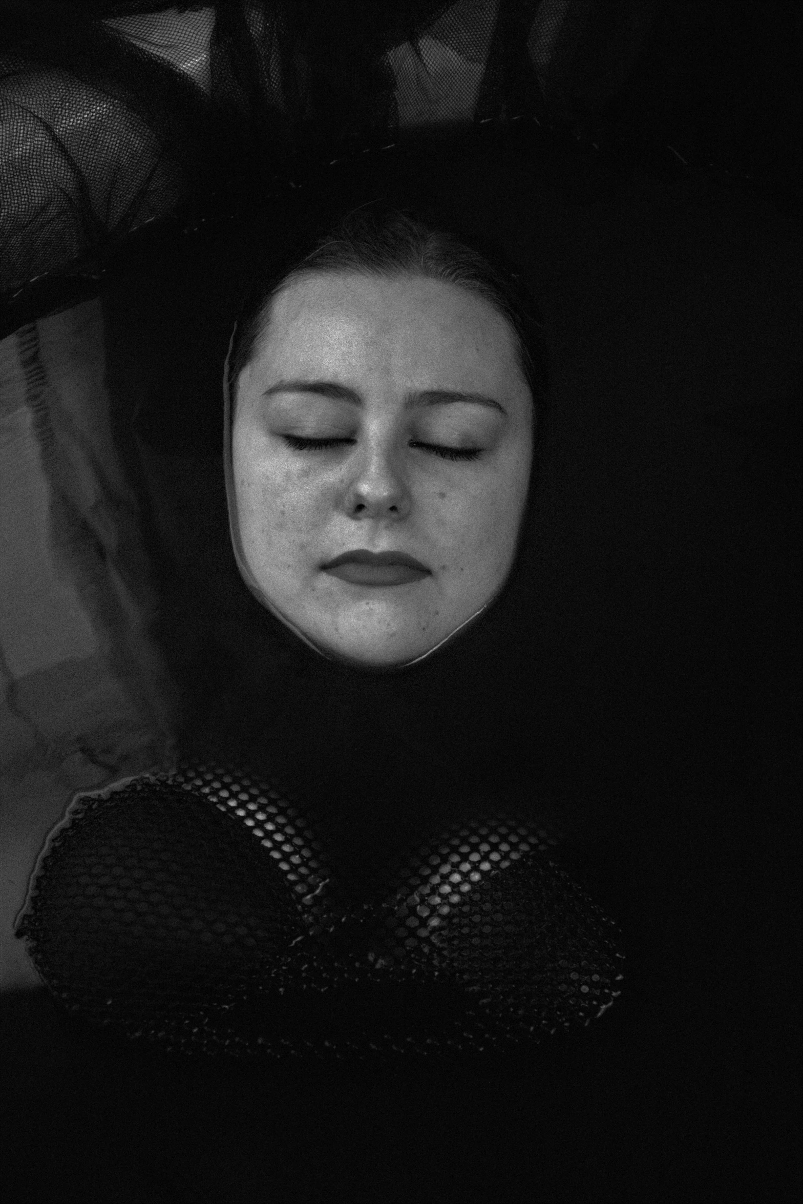 a woman is laying down with her head close to her chest