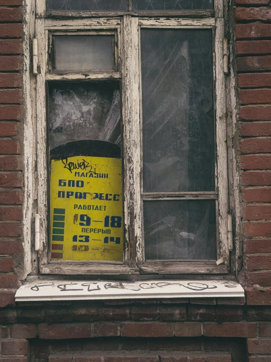 a yellow caution sign that is on the window sill