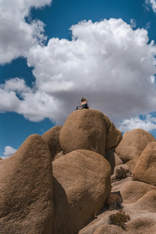 a person sitting on top of a large mound of hay