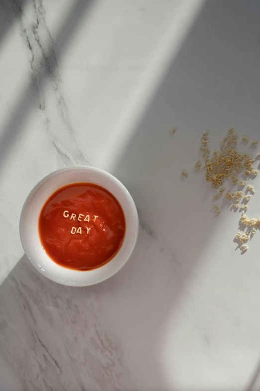 a bowl of red sauce with a seed sprinkle in the corner