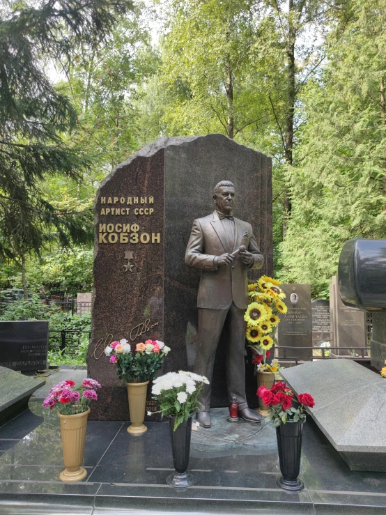 statue and flowers around the base of a memorial