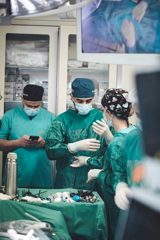 a medical team standing around a counter looking at cell phones