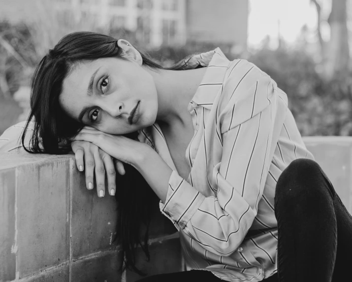 black and white po of a young woman leaning on a wall