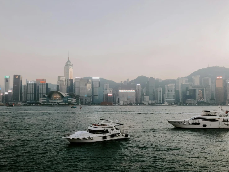 several boats are parked on the water by the city skyline