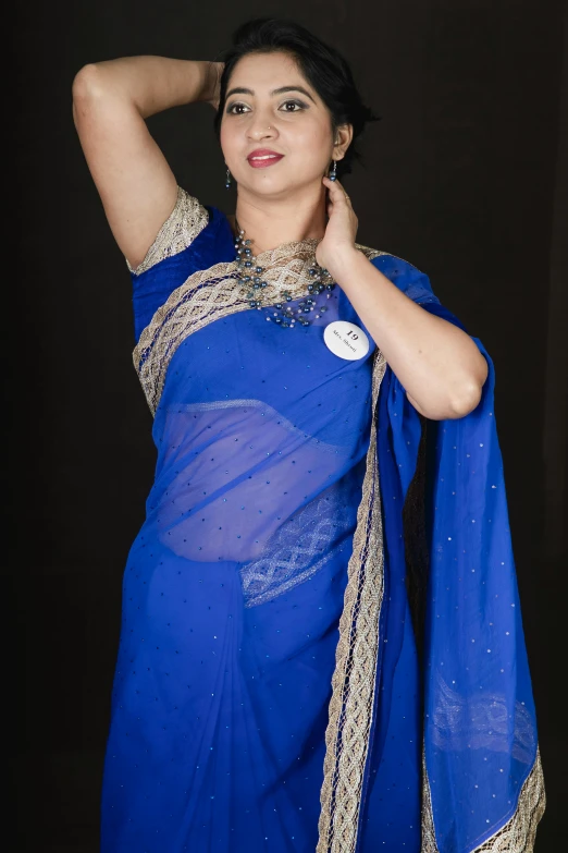 a pretty woman dressed in blue and gold posing for a po