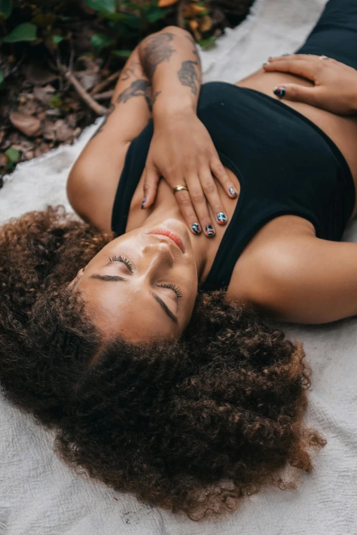 a woman laying on the ground with her hands on her hips