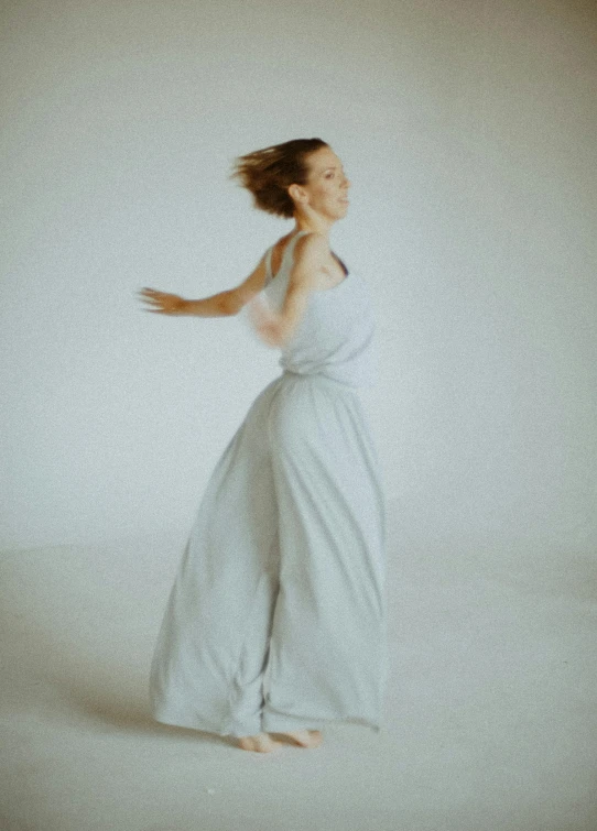 a woman standing in a white dress with a headband