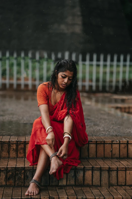 a girl in a red dress sitting on the steps