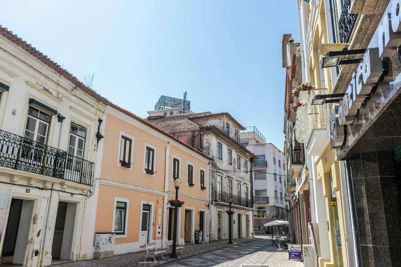 a narrow street with old buildings and sign in it