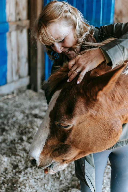 a woman is holding the end of her horse