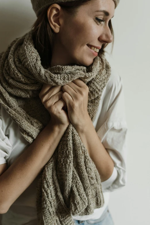 a woman smiling with her hands wrapped around her neck