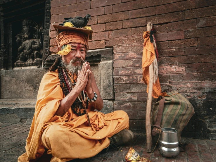 an old man is praying in front of the stone wall